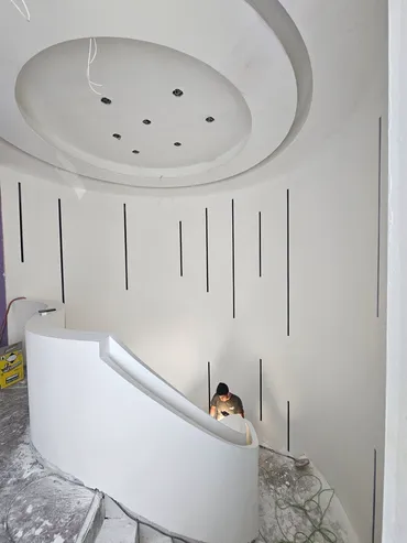 Circular finished ceiling dome above a curved wall with vertical reveals