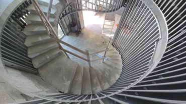 Spiral concrete stair inside a curved metal stud enclosure
